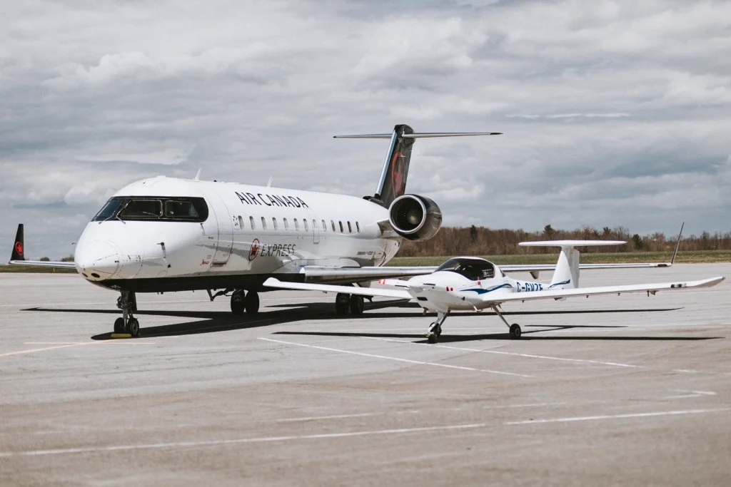 Two aircraft on a runway in a bright sunny day.