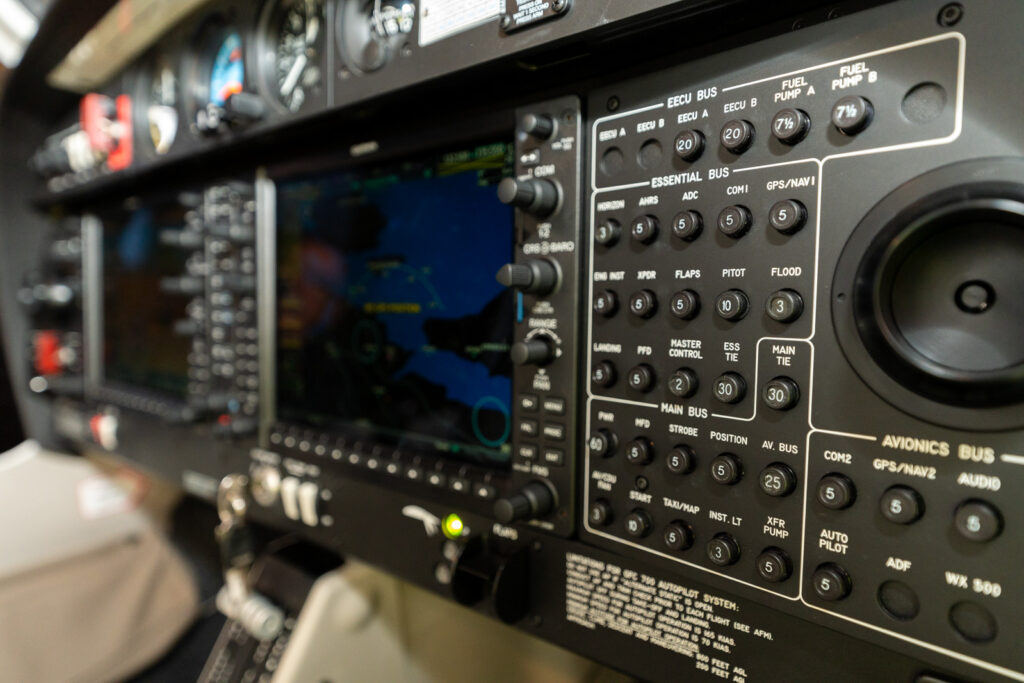 Close‑up view of a modern aircraft avionics panel with digital flight displays and controls

