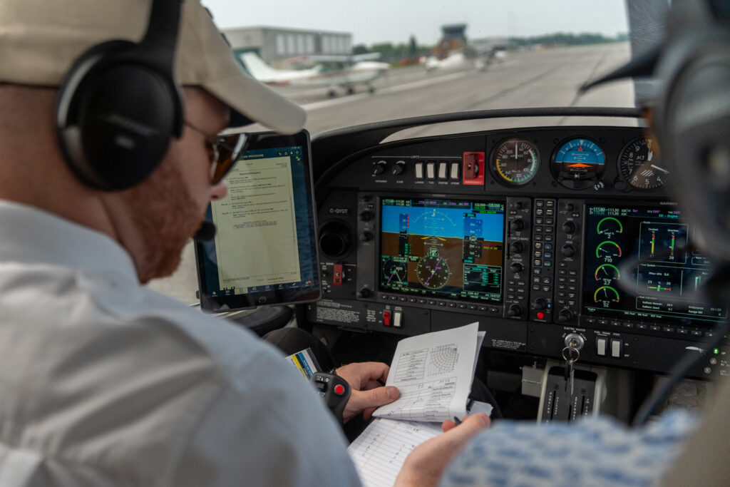 Pilot reviewing a checklist in a glass‑cockpit training aircraft

