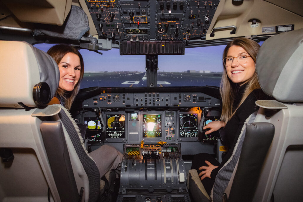 Two pilot trainees seated in an airline cockpit during flight training

